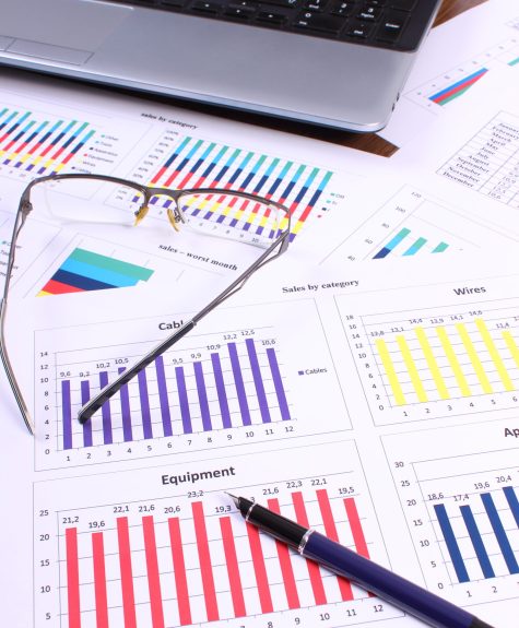 Pen, glasses and laptop on financial graph, business concept Pen, glasses and laptop on financial chart, business concept, analysis of sales plan, business report, business work station with paperwork